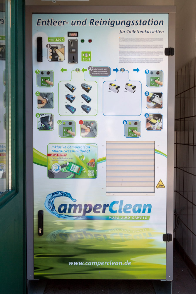 Vorderansicht einer CamperClean-Maschine zum Entleeren und Reinigen von Toilettenkassetten, mit Anweisungen, Tasten und Zahlungsoptionen.